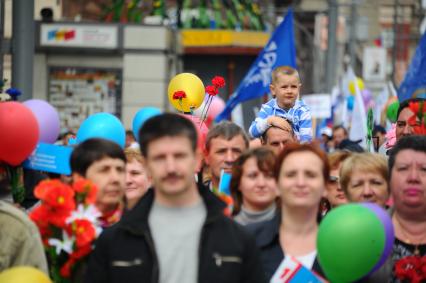 Участники первомайского шествия на улицах Москвы. На снимке: ребенок сидит на плечах отца.