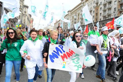 Участники первомайского шествия профсоюзов на улицах Москвы. На снимке: молодежь несетв руках плакат `Мир Май Труд`.