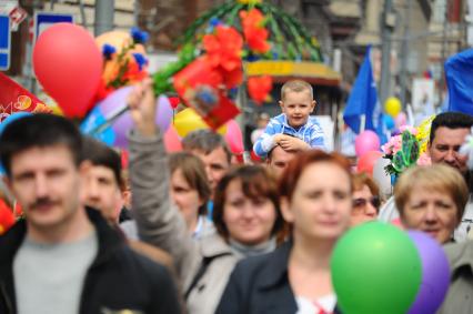 Участники первомайского шествия на улицах Москвы. На снимке: ребенок сидит на плечах отца.