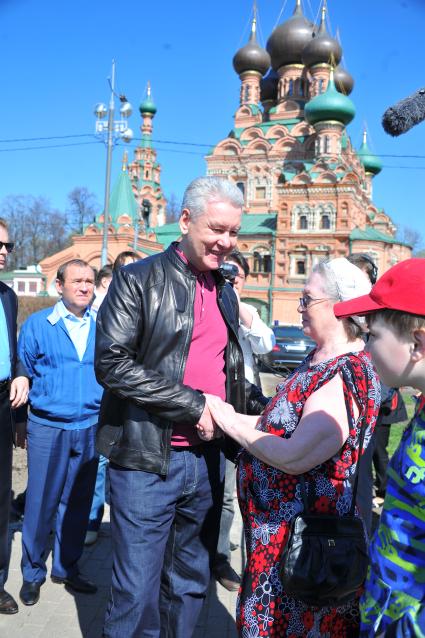 Мэр Москвы Сергей Собянин принял участие в субботнике в столичном парке `Останкино`. На снимке: Мэр Москвы Сергей Собянин общается с народом. Храм Животворящей Троицы (на заднем плане).