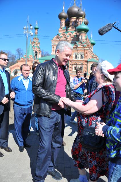 Мэр Москвы Сергей Собянин принял участие в субботнике в столичном парке `Останкино`. На снимке: Мэр Москвы Сергей Собянин общается с народом. Храм Животворящей Троицы (на заднем плане).