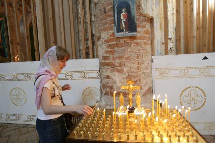 Воскресенский Новоиерусалимский мужской ставропигиальный монастырь. На снимке: прихожанка ставит свечку за упокой в Воскресенском соборе.