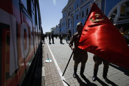 Ставрополь встречает солдат, вернувшихся с фронта. Сюда прибыл специальный агитационный ретро-поезд `Победа` на паровой тяге, состоящий из исторического подвижного состава. На снимке мимо поезда проходят солдаты со знаменем в руках.