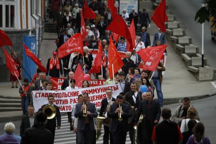 Первомайская демонстрация на улицах Ставрополя. Колонна людей с плакатами, флагами и транспарантами идет по улицам города.