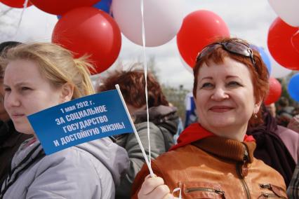 Митинг профсоюзов и ЕР. На снимке две женщины, в руке одной из них флажок с надписью: `1 мая 2012 года. За социальное государство и достойную жизнь`. 1 мая. Барнаул. Площадь Сахарова.