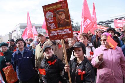 Митинг КПРФ. На снимке толпа митингующих, на переднем плане два мальчика, один из них держит плакат с портретом Сталина и надписью: `С праздником! Сталин это порядок, успех и победа, с КПРФ поднимем Россию с колен. Слава советскому народу победителю`.