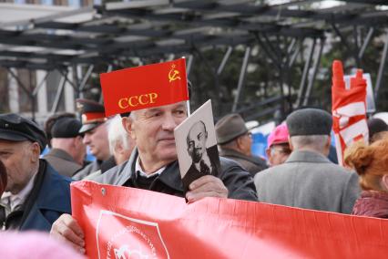 Митинг КПРФ. На снимке пожилой мужчина держит транспарант, флаг СССР и портрет Ленина. 1 мая. Барнаул. Площадь Советов.