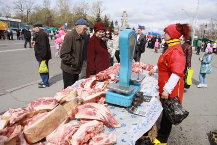 Продуктовая ярмарка. На снимке люди выбирают кусок мяса.  1 мая. Барнаул. Площадь Сахарова.