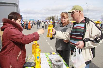 Продуктовая ярмарка. На снимке покупатель держит в руках бутылку подсолнечного масла. 1 мая. Барнаул. Площадь Сахарова.