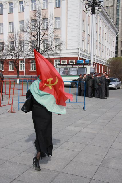 Митинг КПРФ. Женщина идет с флагом СССР мимо полицейских.