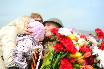 Ветераны во время празднования 67-й годовщины победы в Великой Отечественной войне. На снимке: ветеран ВОВ целует малыша.