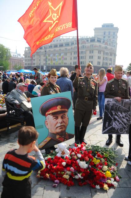 Ветераны во время празднования 67-й годовщины победы в Великой Отечественной войне. На снимке: цветы у плаката с портретом Сталина.и