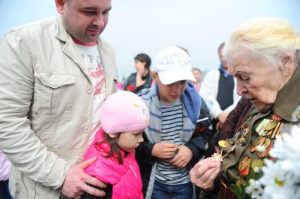 Ветераны во время празднования 67-й годовщины победы в Великой Отечественной войне. На снимке: ветеранка ВОВ показывает свои награды детям.