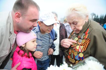 Ветераны во время празднования 67-й годовщины победы в Великой Отечественной войне. На снимке: ветеранка ВОВ показывает свои награды детям.