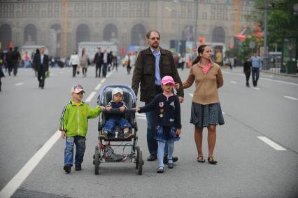 Семейная прогулка. На снимке: родители с детьми на городской улице.