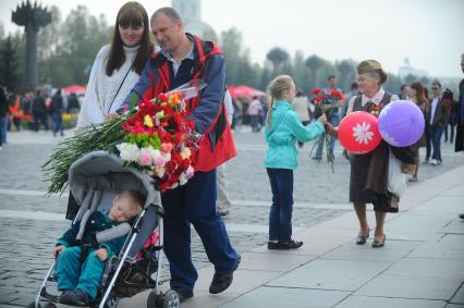 9 мая. Семейная прогулка. На снимке: родители с ребенком на городской улице.