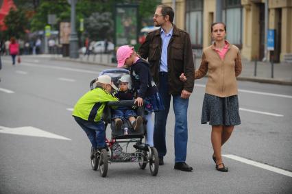 Семейная прогулка. На снимке: родители с детьми на городской улице.