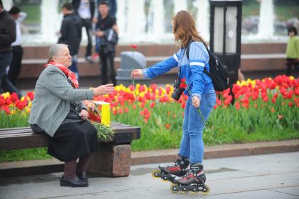 9 мая. На снимке: девушка поздравляет пенсионерку с Днем Победы.