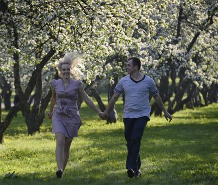 Жанровая фотография.  Свидание. На снимке: влюбленные в яблоневом саду.