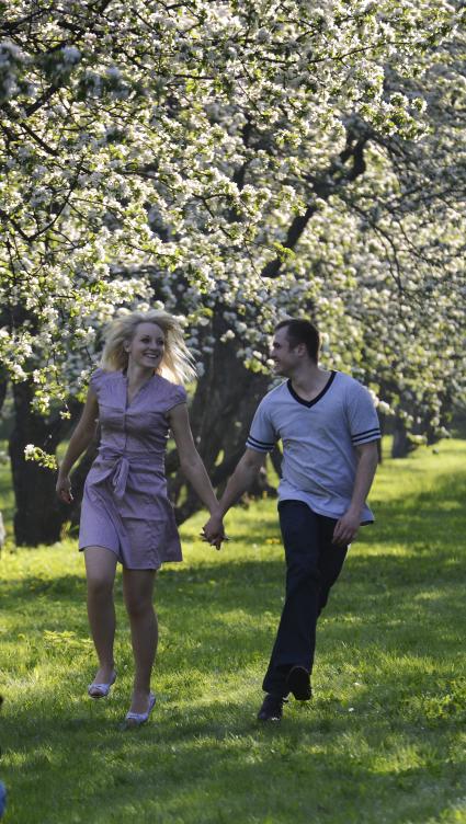 Жанровая фотография.  Свидание. На снимке: влюбленные в яблоневом саду.