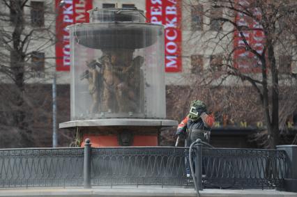 Рабочий сдувает пыль с ограждений.