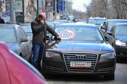 Акция `СТОП- ХАМ` на Тверском бульваре. На снимке: автовладелец снимает прилепленную на стекло автомобиля наклейку с подписью `Мне плевать на всех- паркуюсь где хочу`.