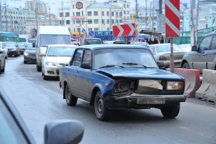 По дороге едет автомобиль ВАЗ без фары.