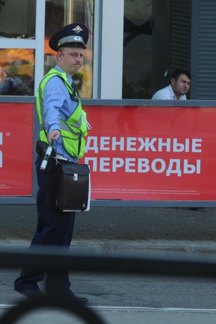 Полицейский перед табличкой Денежные переводы.