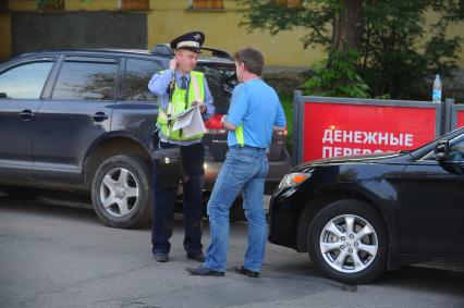 Полицейский  выписывает водителю штраф.