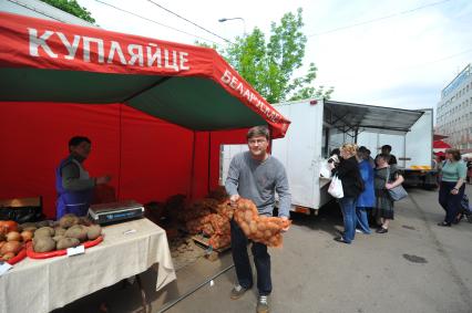 Белорусская ярмарка. На снимке: мужчина держит в руках сетку с картофелем.