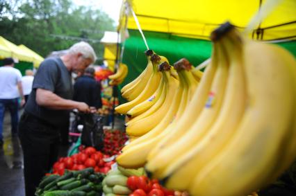 Ярмарка выходного дня. На снимке: мужчина возле палатки с фруктами и овощами.