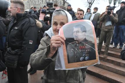 Фильм НТВ `Анатомия протеста` спровоцировал митинг на Пушкинской площади. На снимке: пожилая женщина с портретом И. В. Сталина.