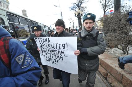 Фильм НТВ `Анатомия протеста` спровоцировал митинг на Пушкинской площади. На снимке: полиция задерживает мужчину с плакатом `Страна опускается! Востановим советский союз`.