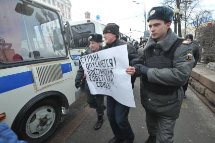 Фильм НТВ `Анатомия протеста` спровоцировал митинг на Пушкинской площади. На снимке: полиция задерживает мужчину с плакатом `Страна опускается! Востановим советский союз`.