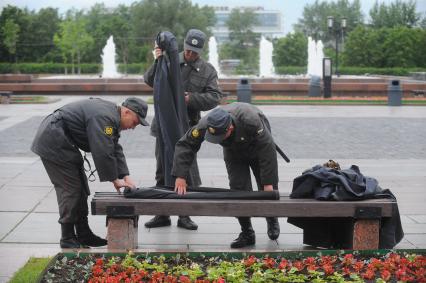 Полицейские сворачивают дождевики на Поклонной горе.