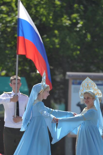 Выпуск лейтенантов военно- технического университета (ВТУ) спецстроя России. На снимке: молодой лейтенант держит российский флаг перед танцующими в народных костюмах девушками.