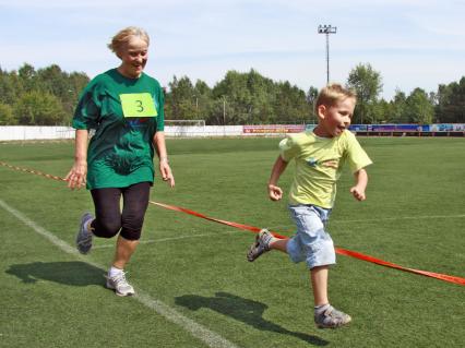 Бабушка бежит на перегонки с внуком.