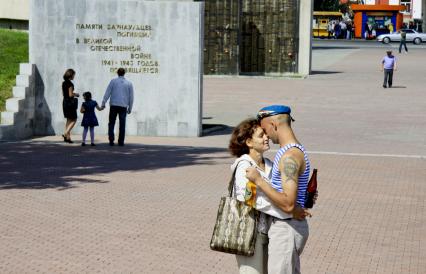 День ВДВ. Мужчина в десантном берете и тельняшке обнимается с женщиной.