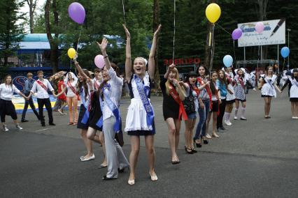 Выпускники веселятся на улице.