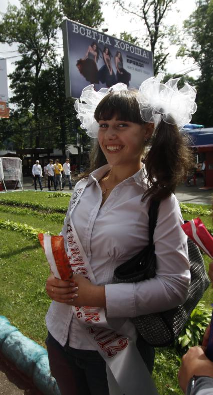 Выпускница на фоне рекламного щита газеты `Комсомольская правда` с надписью `Всегда хороша!`.