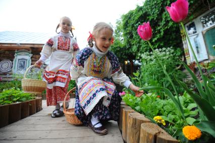 Две девочки в русско- народных костюмах на национальном подворье.