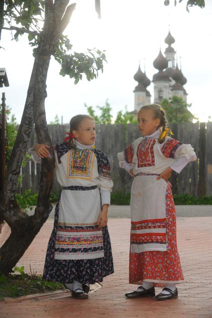 Девочки в русско- народных костюмах на русском подворье на фоне храма.