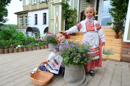 Две девочки в русско- народных костюмах на национальном подворье.