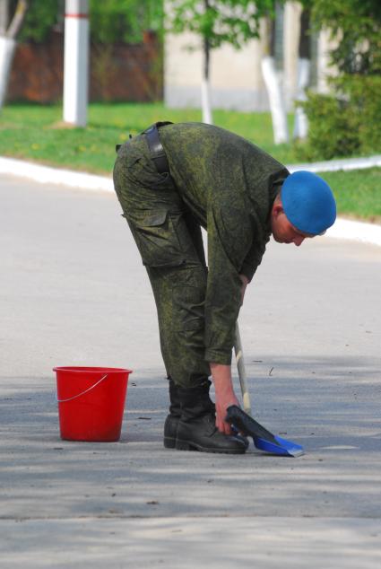 Десантник на плацу подметает.