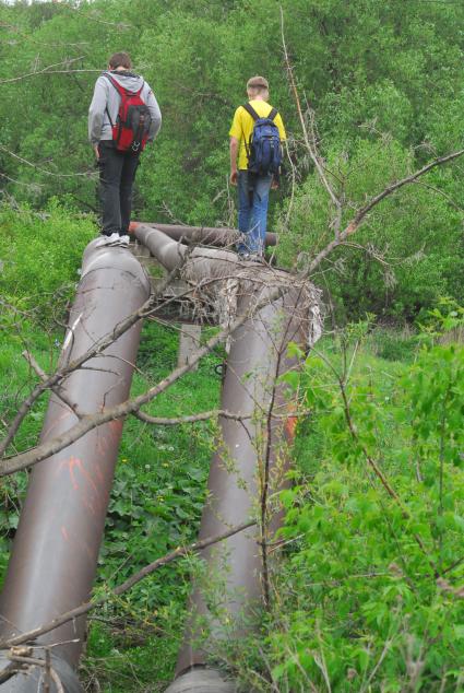 Подростки гуляют по трубам водоснабжения.