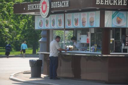 Мужчина у ларька с `Венскими колбасками`