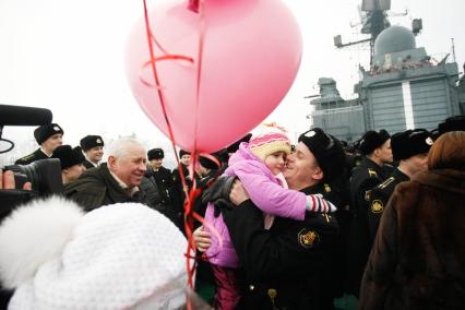 Сторожевик Балтфлота `Ярослав Мудрый` вернулся в порт 14 февраля. Встреча с семьей на борту корабля. Моряк поднимает на руки ребенка.