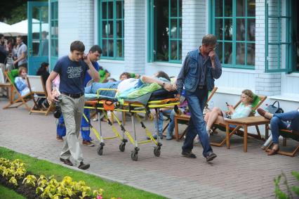\'Фестиваль Мировой Еды\' приурочен к 150-летию журнала \'Вокруг Света\' в саду \'Эрмитаж\'. На снимке: врачи скорой помощи везут на каталке молодого человека, которому стало плохо от переедания.