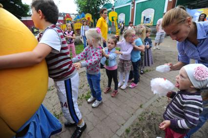 Дети играют в паровозик на детской площадке.