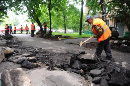 Гастарбайтеры разбивают асфальт во дворе дома.